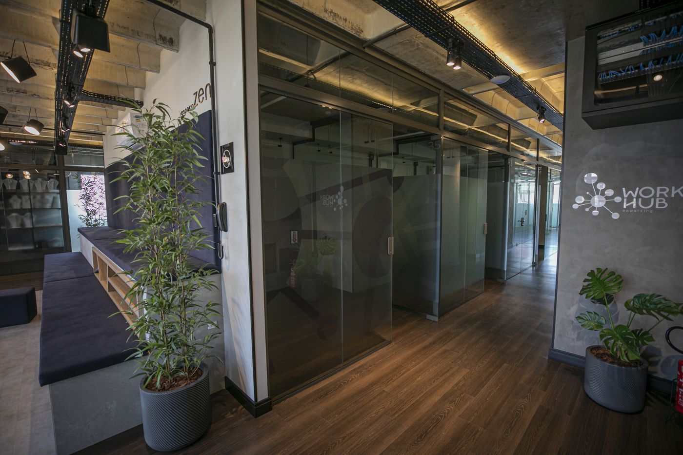 Corredor das salas privativas com portas de vidro no WorkHub Itajaí