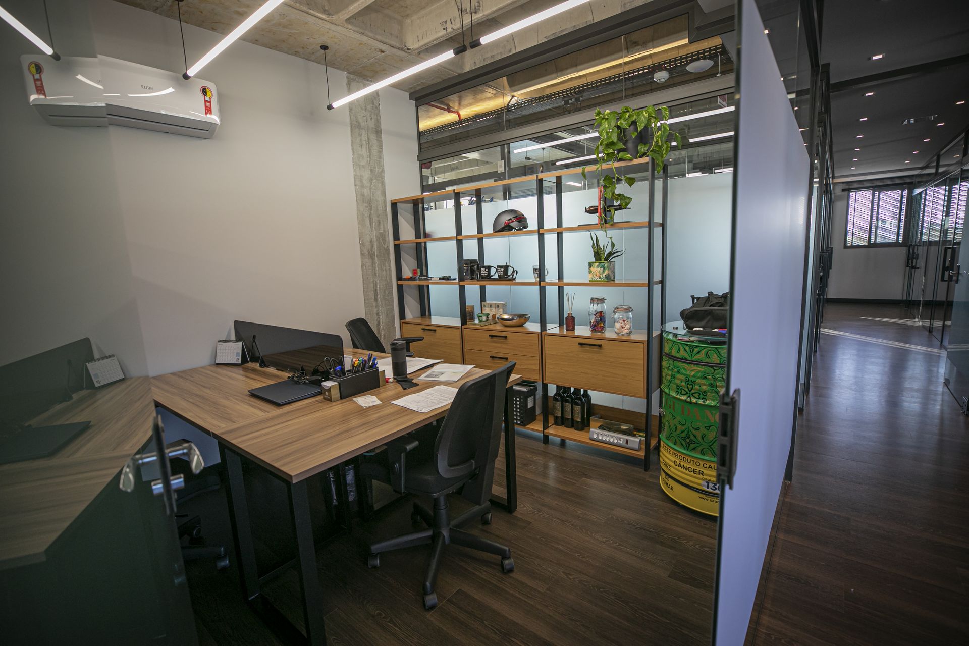Sala privativa equipada, com mesa e estante, no WorkHub Itajaí